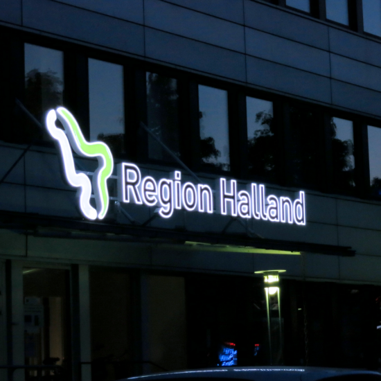 Belyst skylt monterad på skärmtak